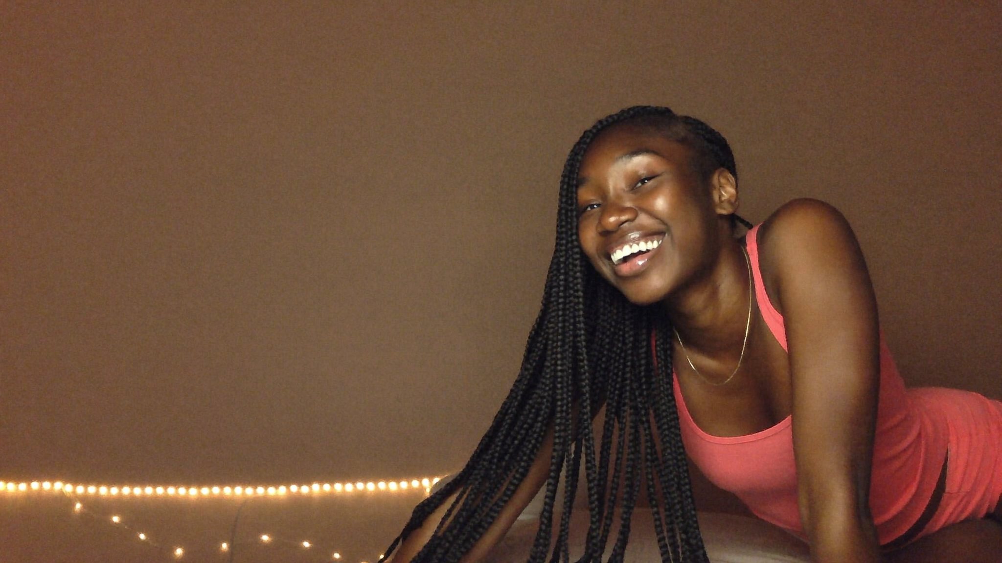 A Latina creator laughing in her room